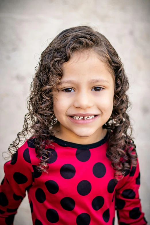 a little girl with a polka dot shirt