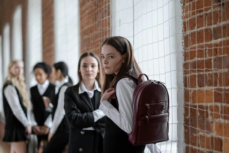 a beautiful woman holding onto a backpack while standing next to other women