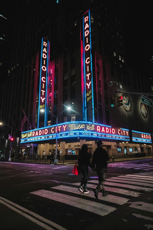 a man riding a bicycle in front of a radio city sign