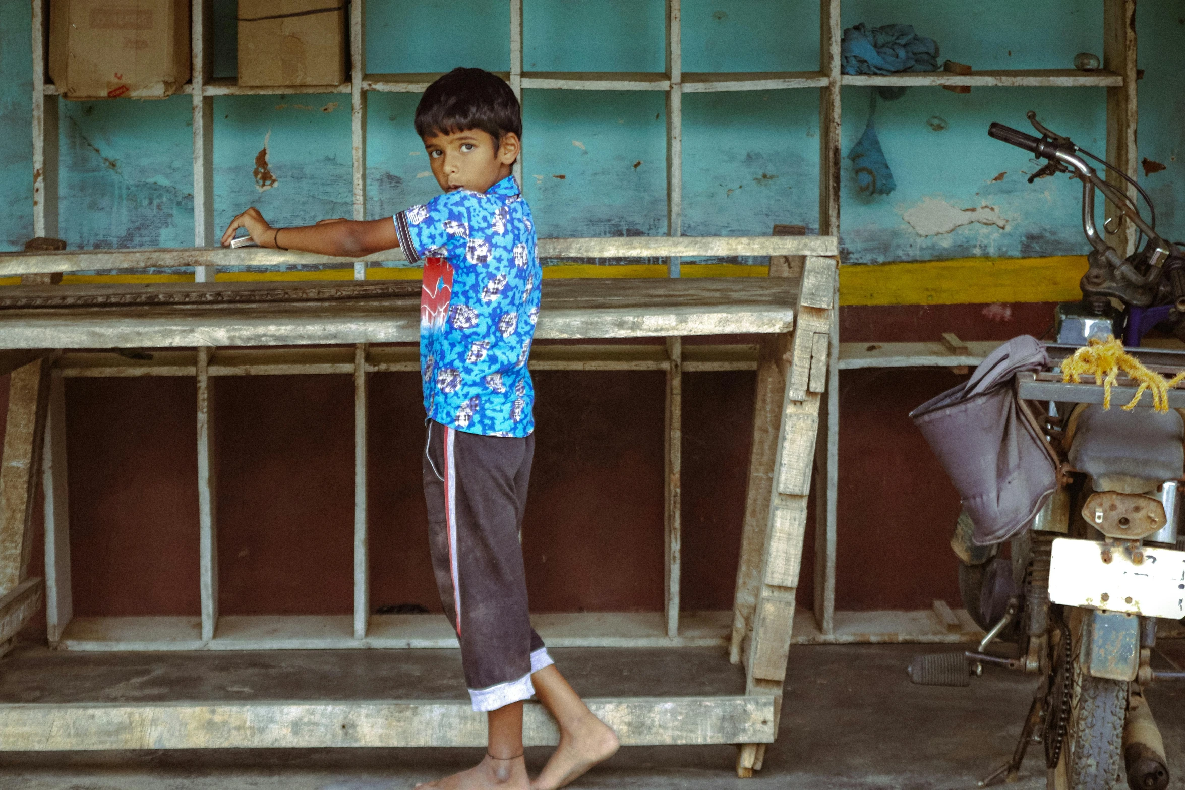 a little boy standing near a window in a room