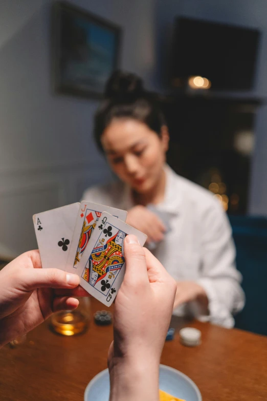 two people are playing cards with each other