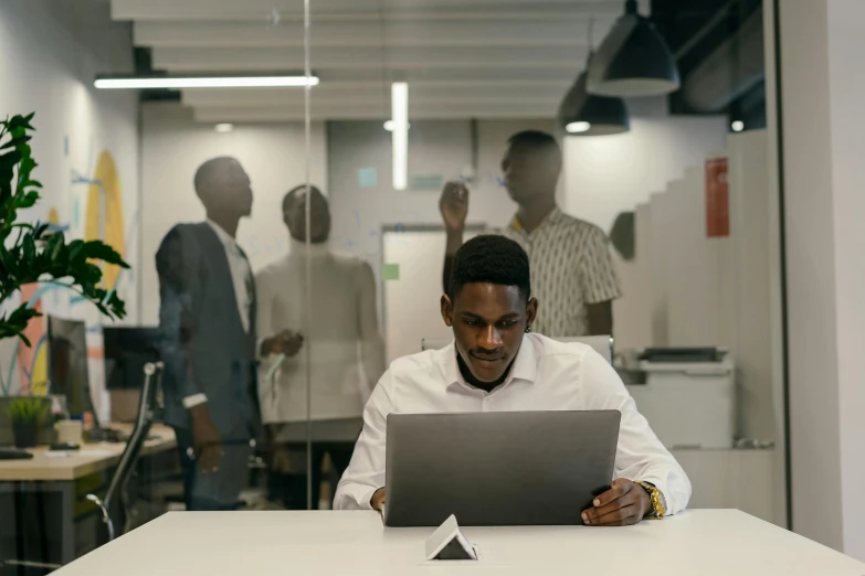 the man is using his computer in an office