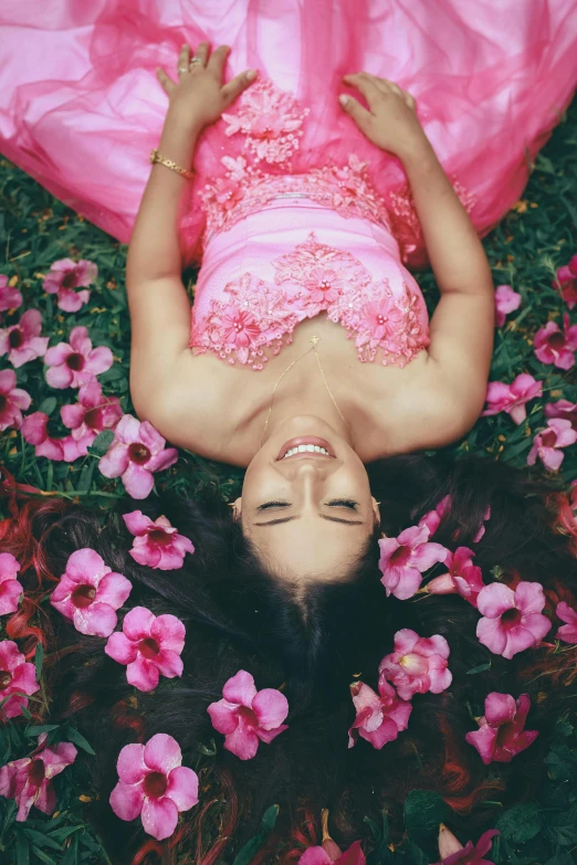 a girl in a pink dress on the ground