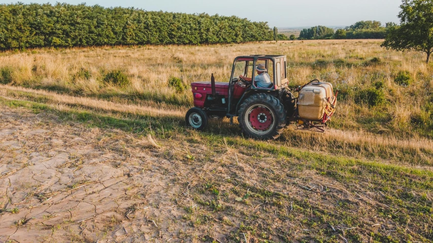 an older farm tractor with a load of hay