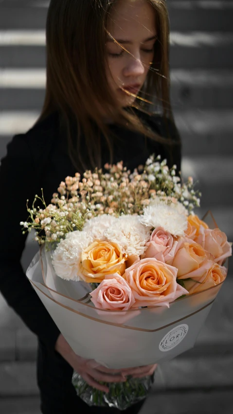 a girl holding a bouquet of flowers in the street