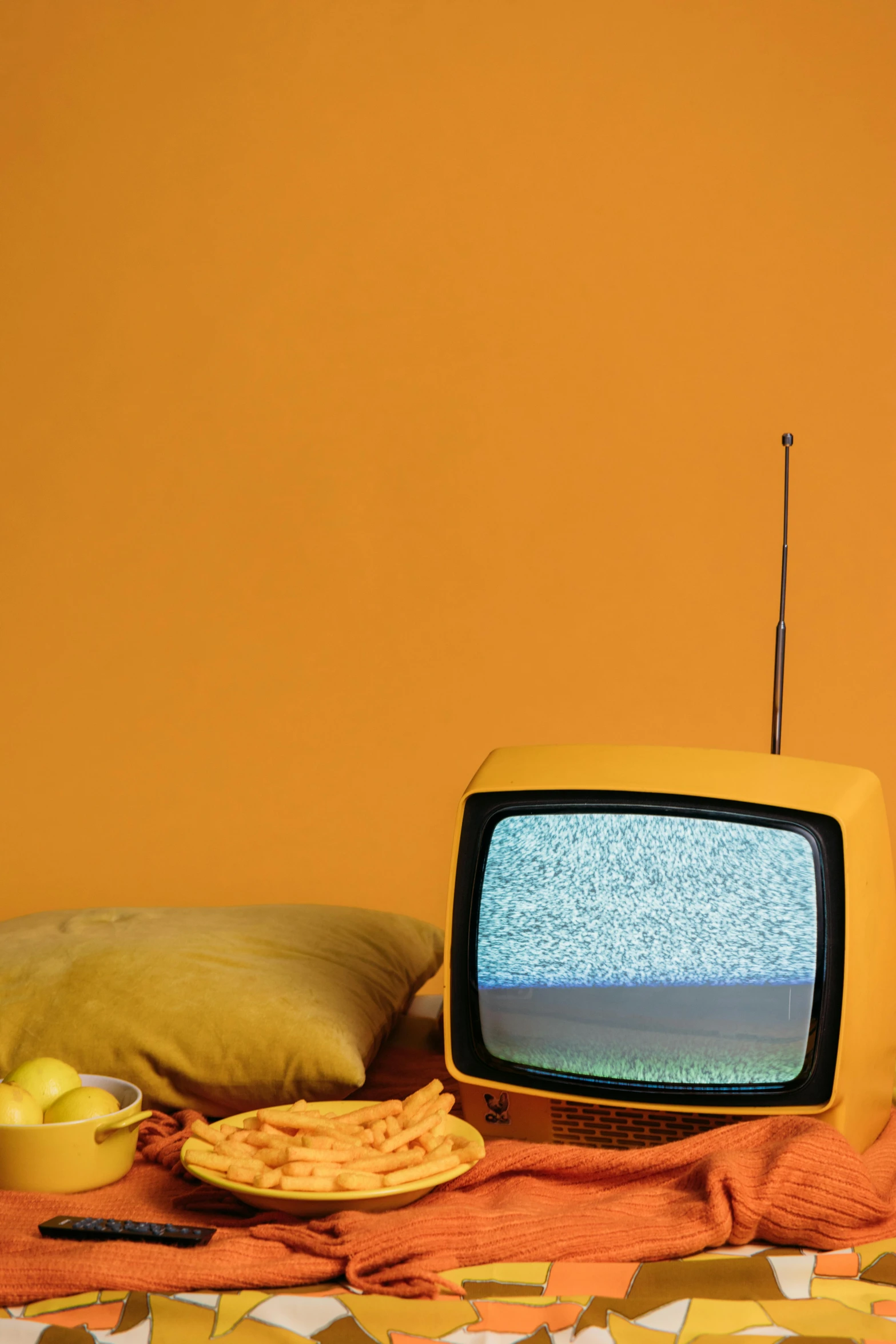 a tv sitting on top of a table next to a pillow