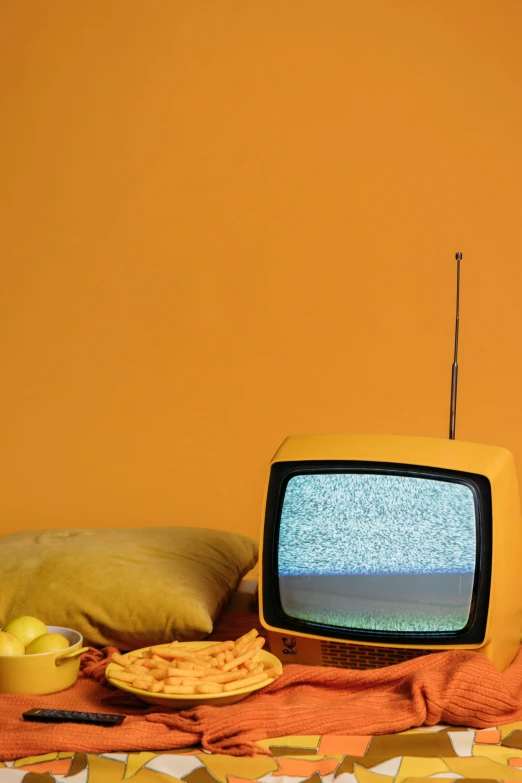 a tv sitting on top of a table next to a pillow