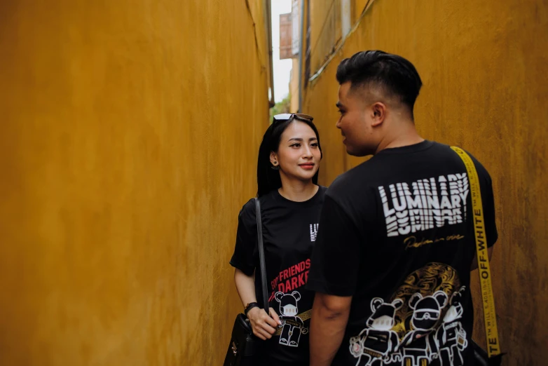 a man and woman standing in the corner of a alley