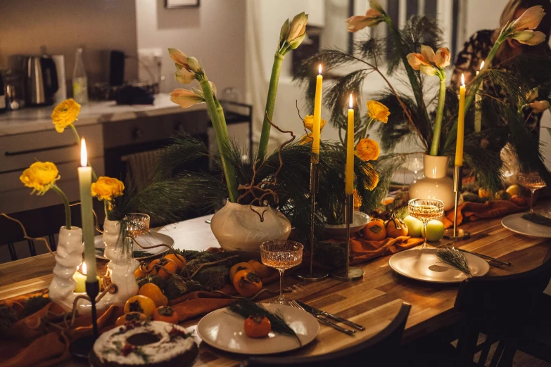 dinner table set up with flowers, candle and fruits