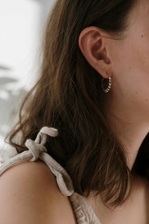 a woman is wearing a pair of earrings with flower decorations on them