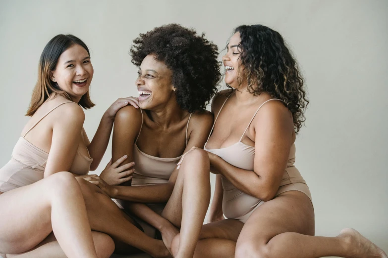 three woman sitting next to each other on a bed