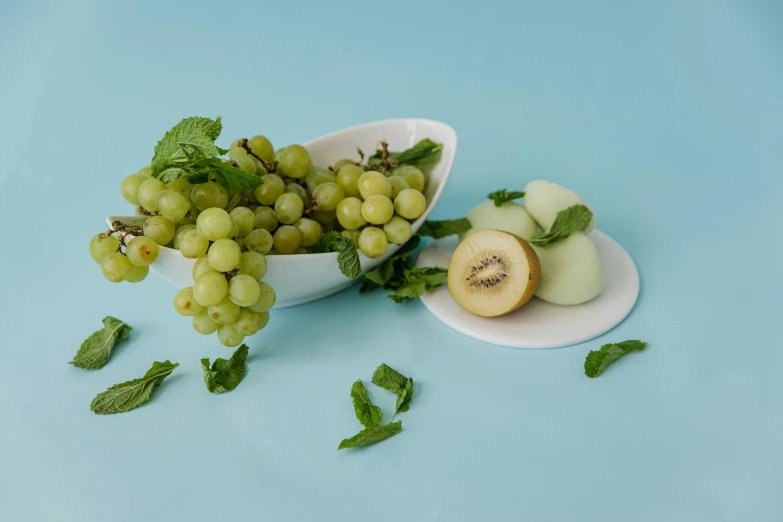 a bowl filled with green gs and a kiwi