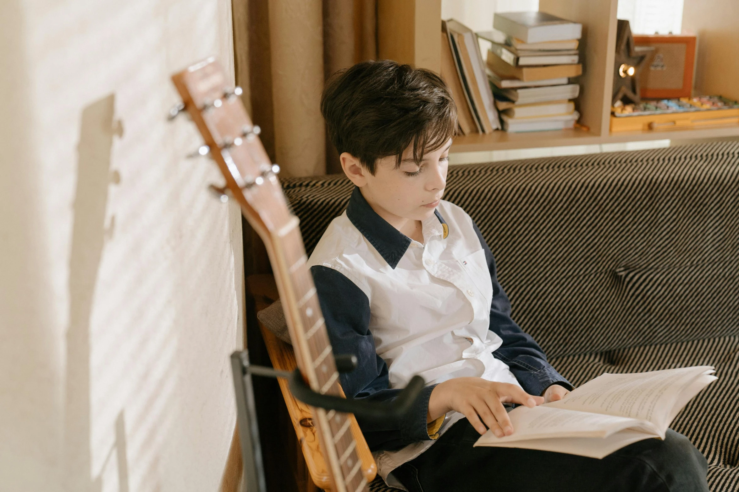 a person sitting on a chair with an acoustic instrument