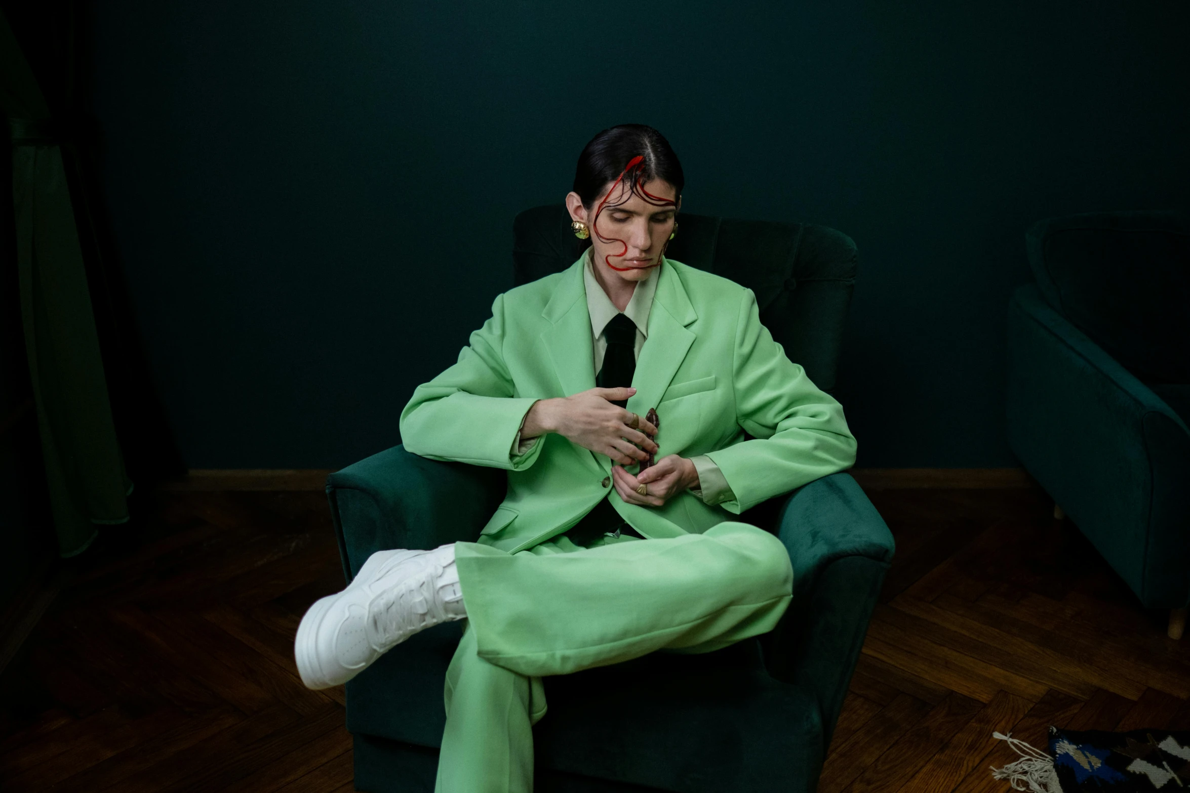 the woman in a green suit is on a dark chair