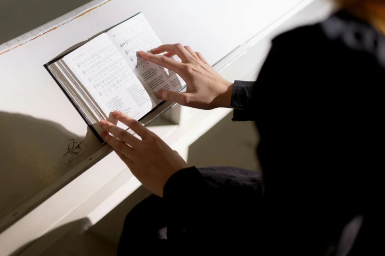 someone holding their hand up on a book