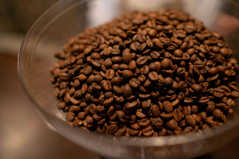 the coffee beans are scattered on a glass bowl