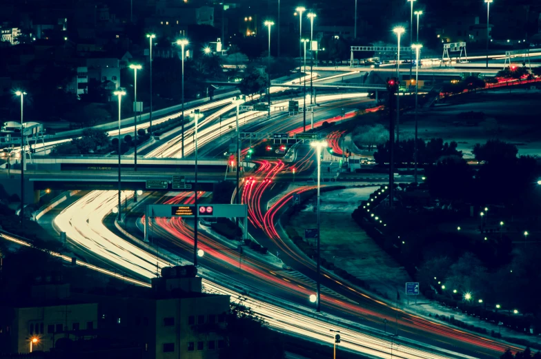 busy highway intersection at night with car light trails