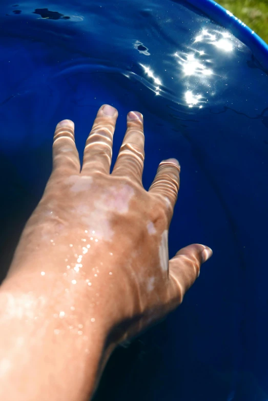 the person in the pool is reaching for the frisbee