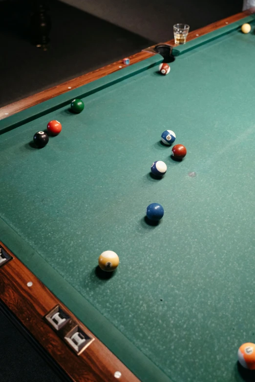 the pool table is green and has lots of balls