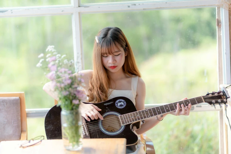 a girl in white dress playing the guitar