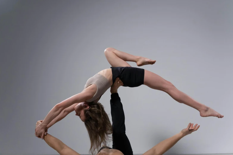 two people doing yoga together on top of one another