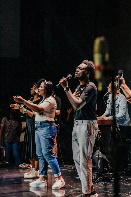 a man and woman stand on a stage while they sing