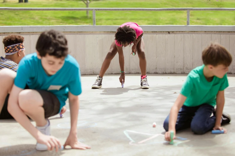 two boys and a girl playing on the pavement