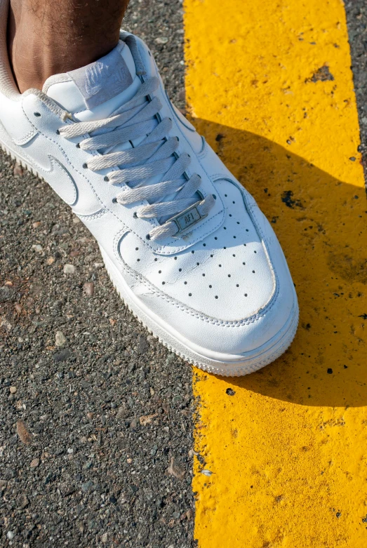 a man is standing on top of a white sneaker