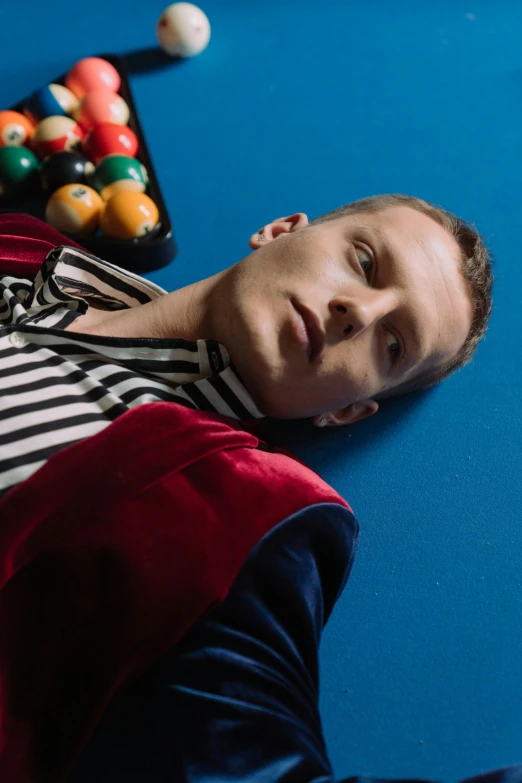 a man laying on top of a pool table