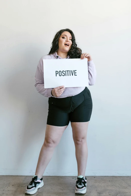 a woman holding up a sign that says positive