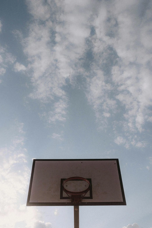 a basketball hoop against a cloudy blue sky