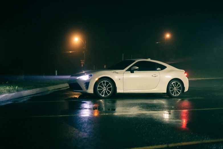 a white sports car in the rain at night