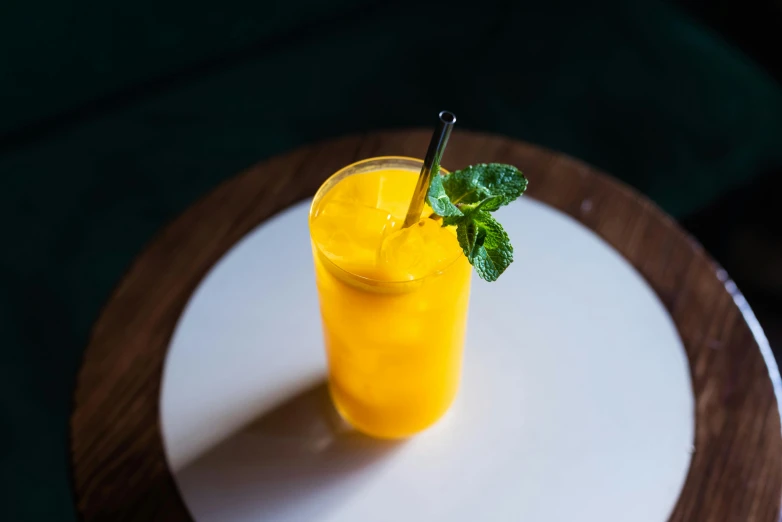 a glass with a green leaf in it sitting on a plate