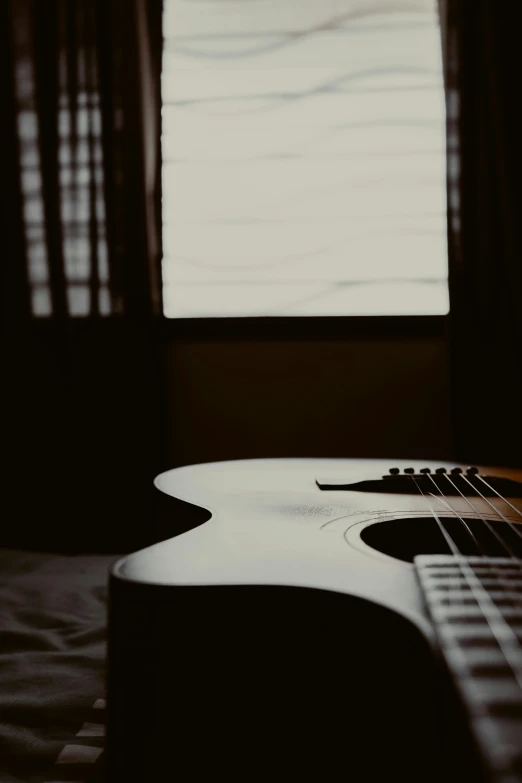 the front of an electric guitar next to a window
