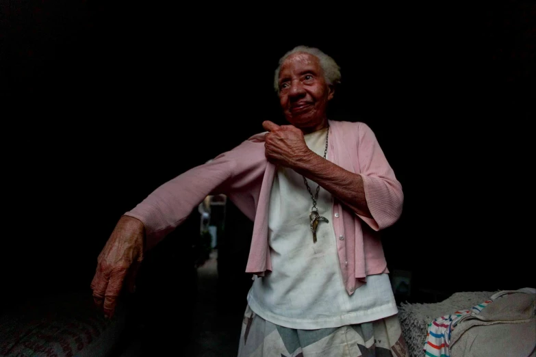 an elderly woman wearing white poses for a pograph