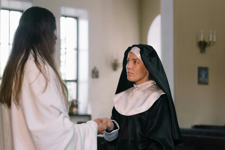 the nun and the woman both are looking towards the mirror