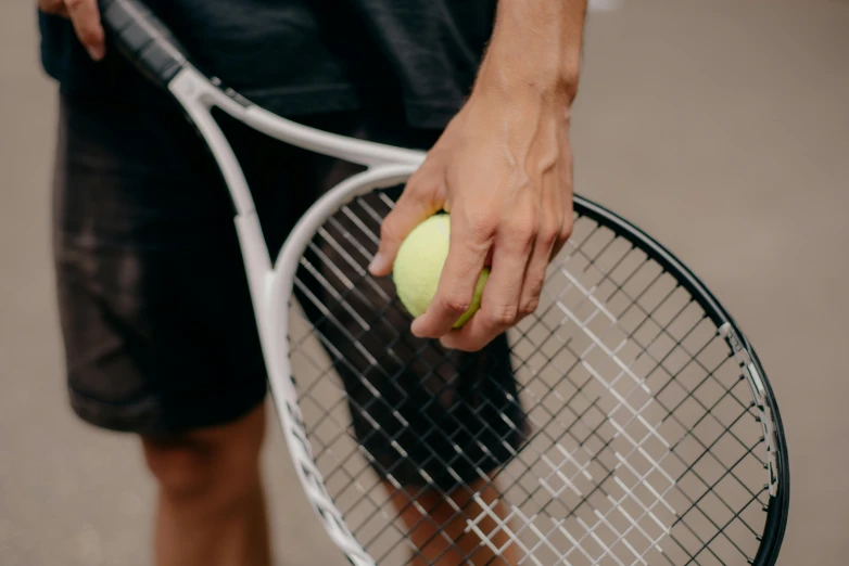 man holding tennis racket holding a tennis ball