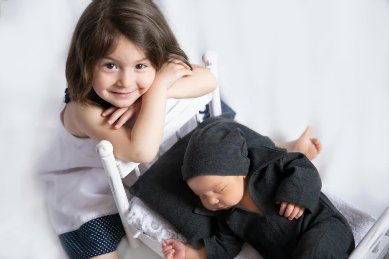 two children on a bed and one has a sleeping position