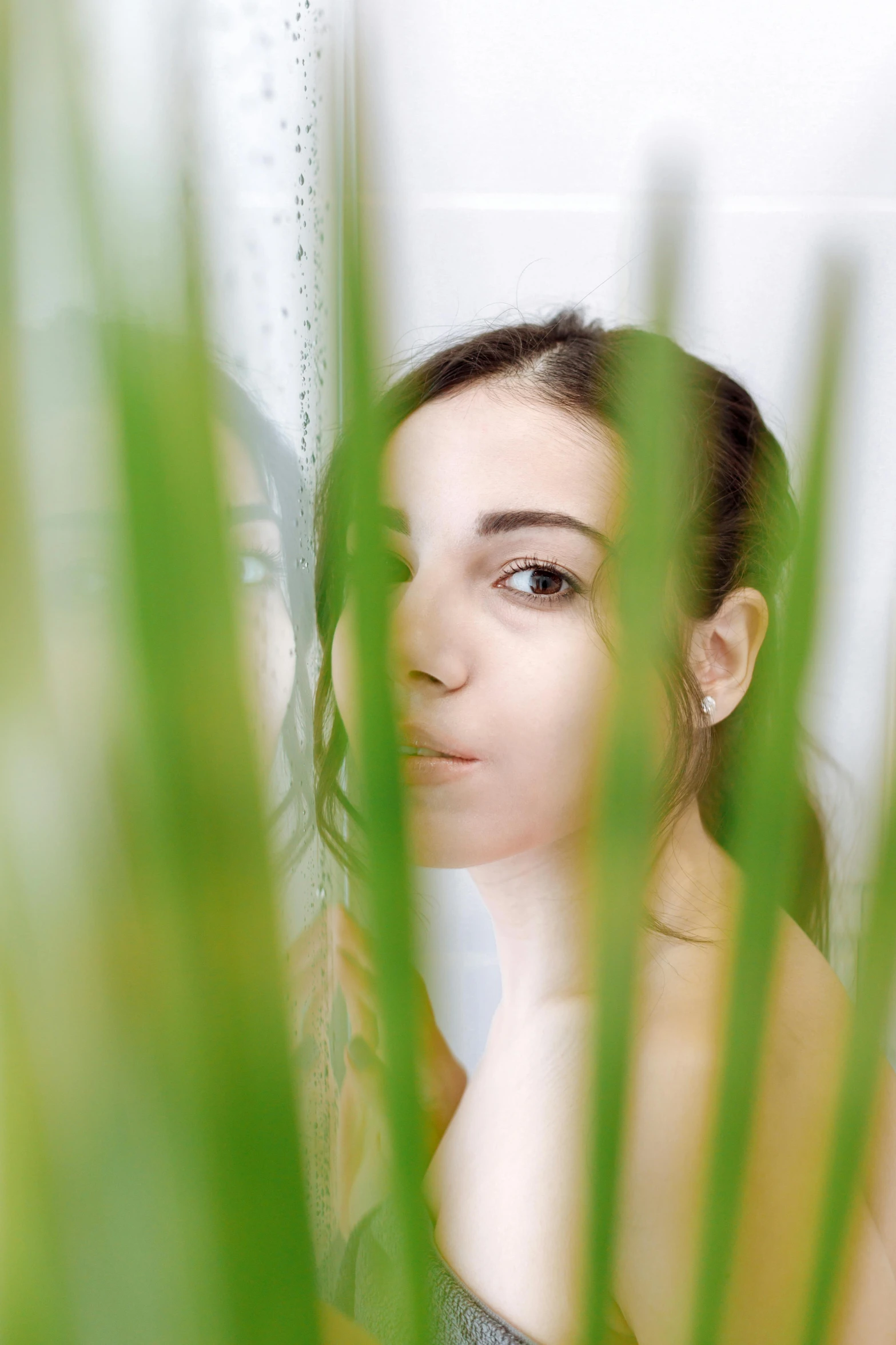 a woman looks off into the distance from tall grass