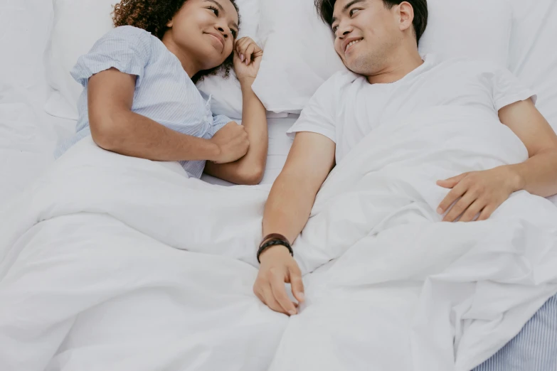 a man and  sleep in their white sheets together