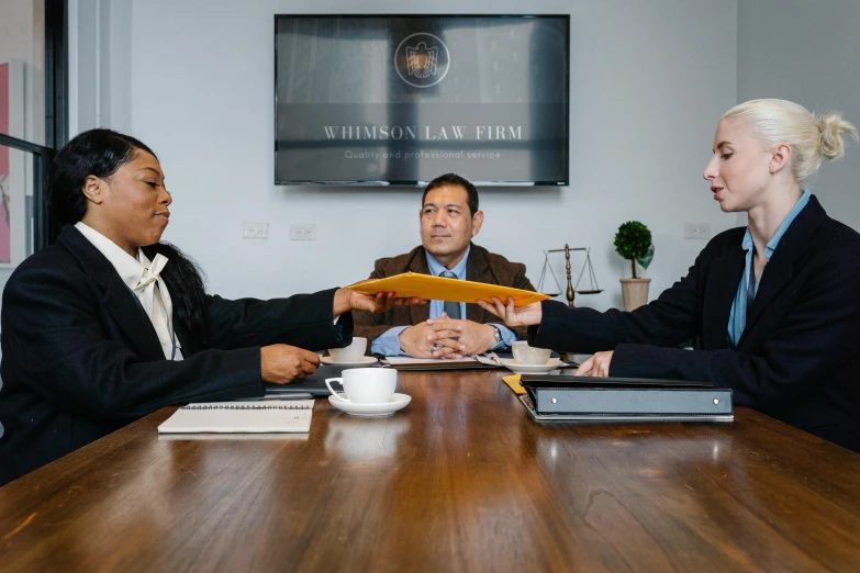 four people sitting at a wooden table discussing soing