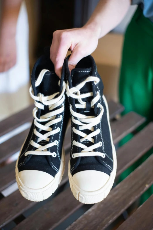 a person tying some shoes on a park bench