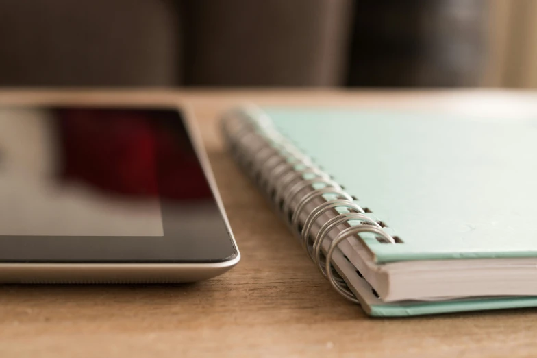 an open notebook next to a cell phone