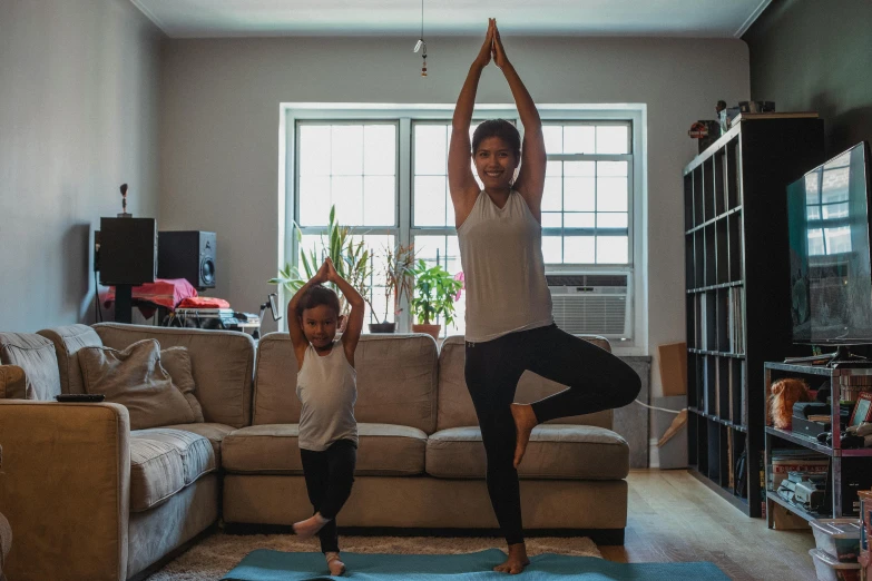 the mother and daughter are practicing yoga