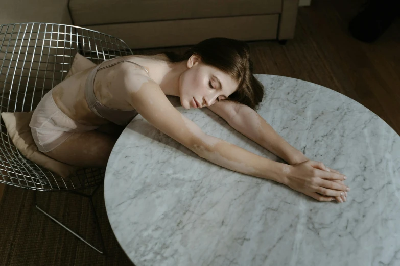 an artistic image of a young woman lying down on a marble table