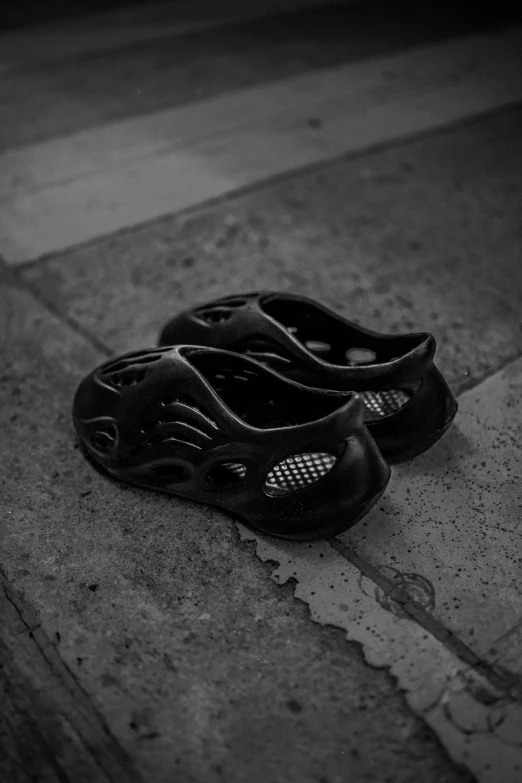 pair of black shoes sitting on cement near street