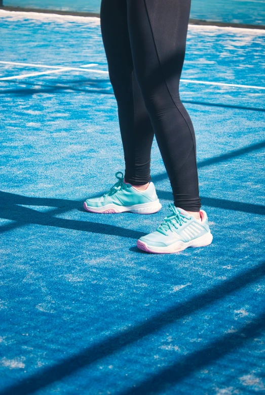 a person standing on a tennis court with a racket