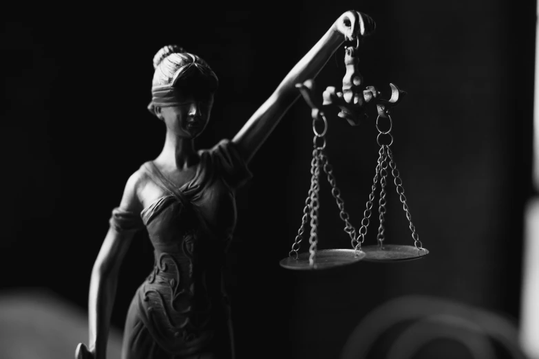 lady justice figurine holding a scale and balance