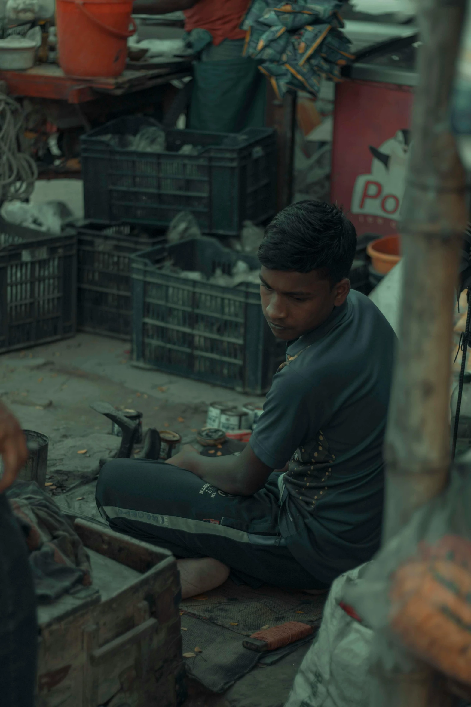 a man sits on the floor working with tools