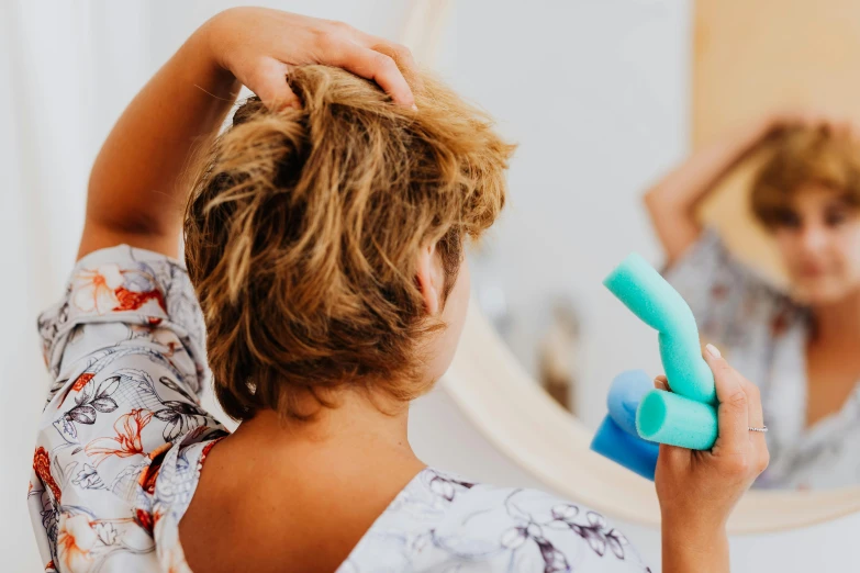 a woman brushing her hair with a blue comb